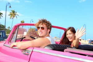 Homme et femme dans une décapotable au soleil