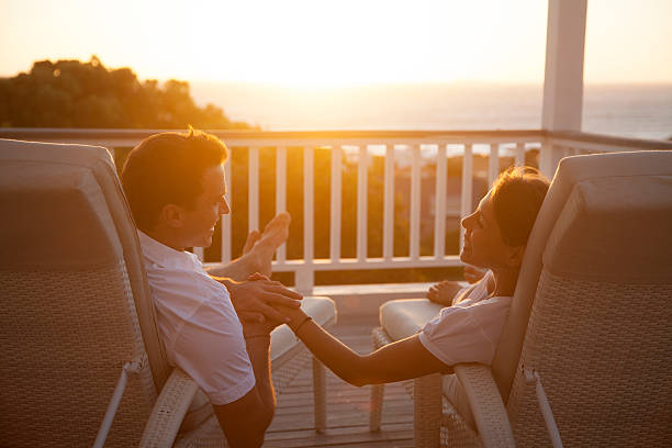 Couple assis sur des transats, sur la terrasse d'un lodge