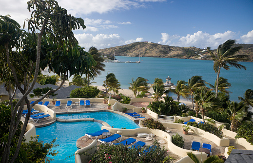 Vue sur la piscine d'un camping avec en arrière-plan la mer et les montagnes