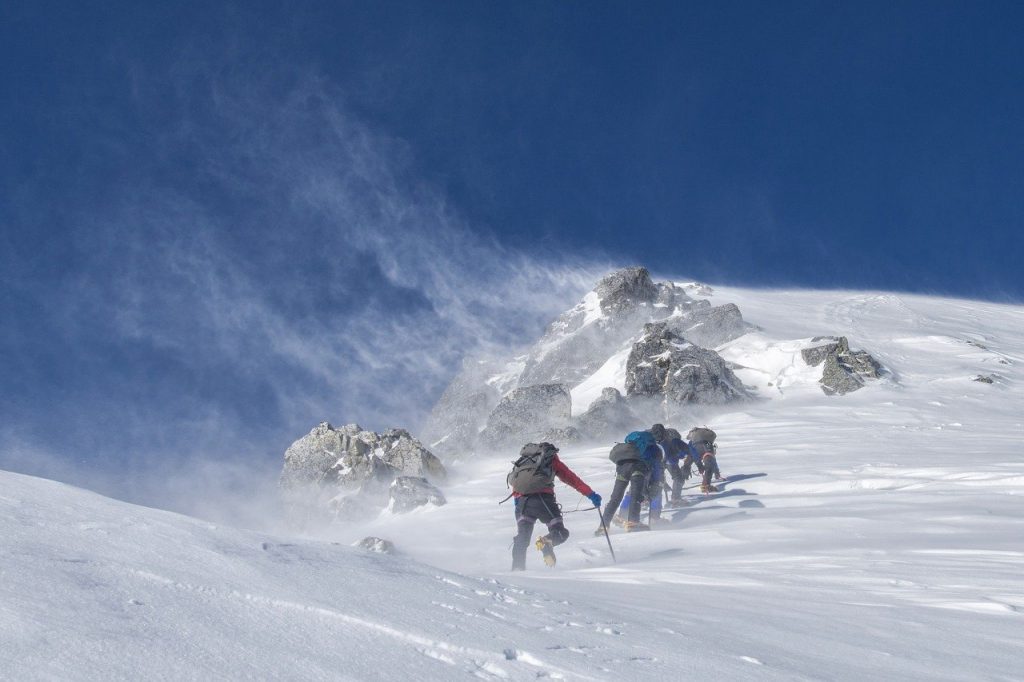 groupe de personnes faisant de l'alpinisme sur une montagne enneigée